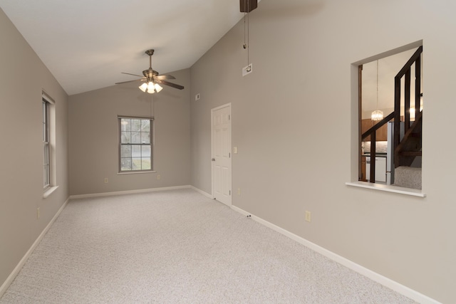 spare room featuring ceiling fan, light carpet, and lofted ceiling