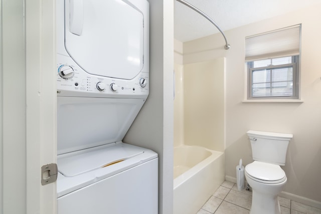 washroom featuring light tile patterned floors and stacked washer / dryer