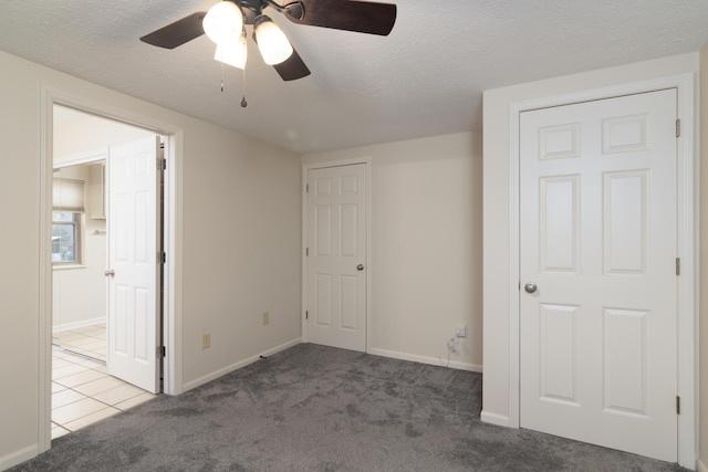 unfurnished bedroom featuring carpet flooring, ceiling fan, and a textured ceiling