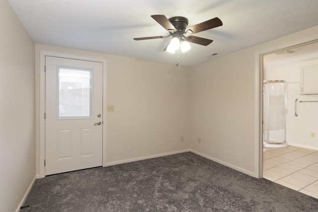 interior space featuring ceiling fan, carpet, and a textured ceiling