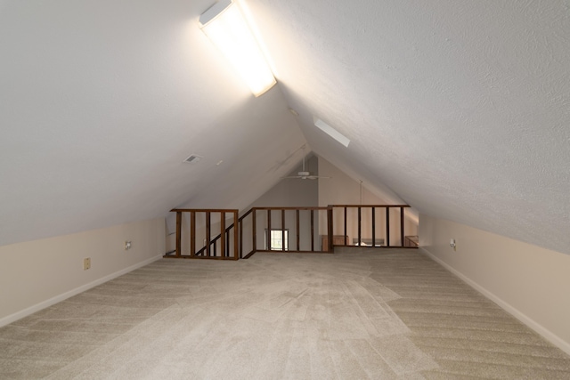 bonus room with light carpet, a textured ceiling, and lofted ceiling