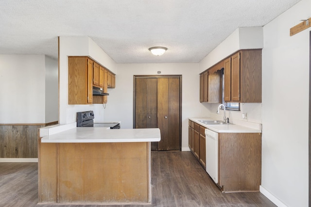 kitchen featuring dishwasher, sink, dark hardwood / wood-style flooring, kitchen peninsula, and stainless steel electric range