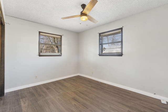 unfurnished room with ceiling fan, dark wood-type flooring, and a textured ceiling