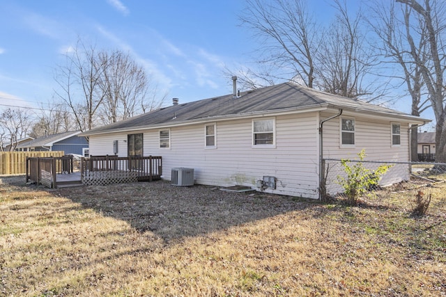 rear view of house featuring central AC unit, a deck, and a lawn