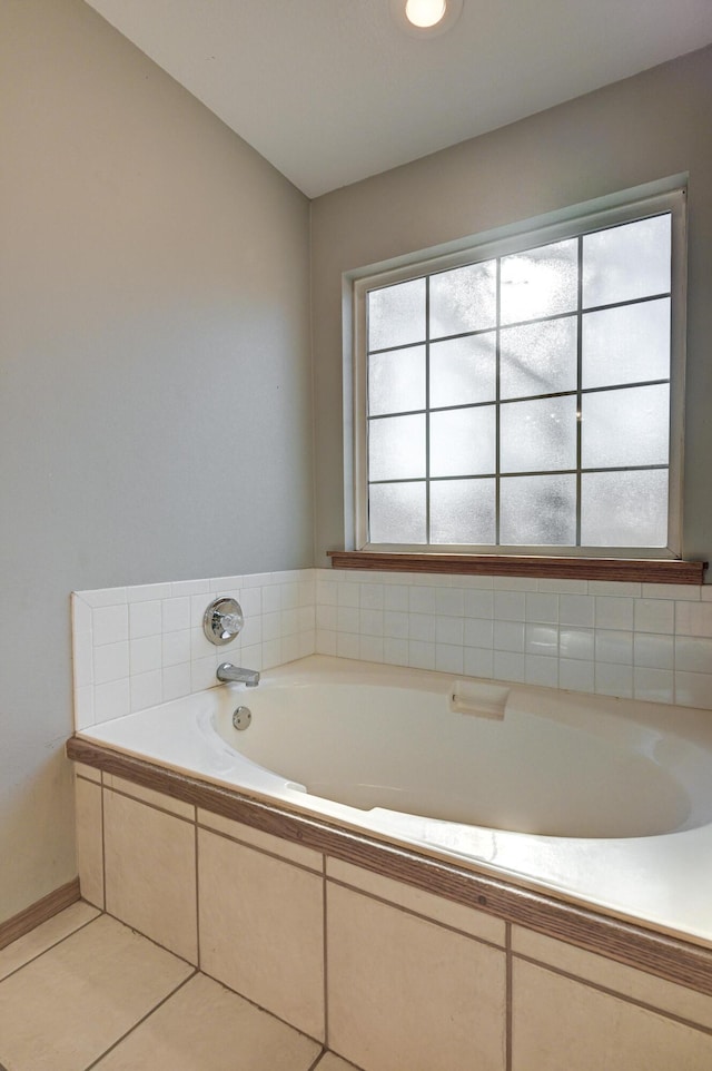 bathroom with tile patterned flooring and tiled bath