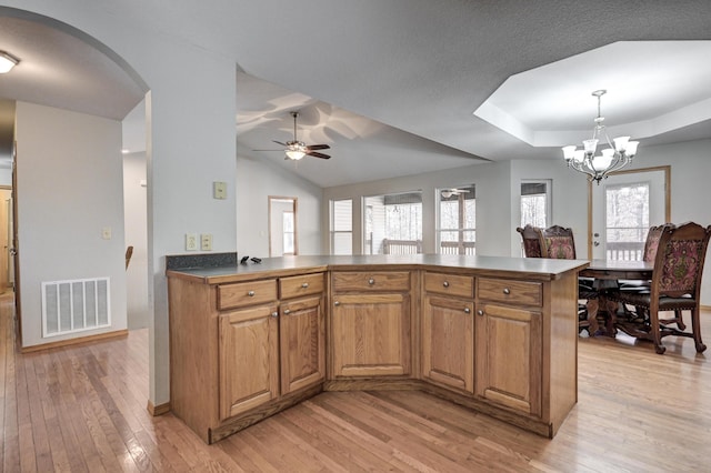 kitchen with plenty of natural light, ceiling fan with notable chandelier, decorative light fixtures, and light hardwood / wood-style flooring