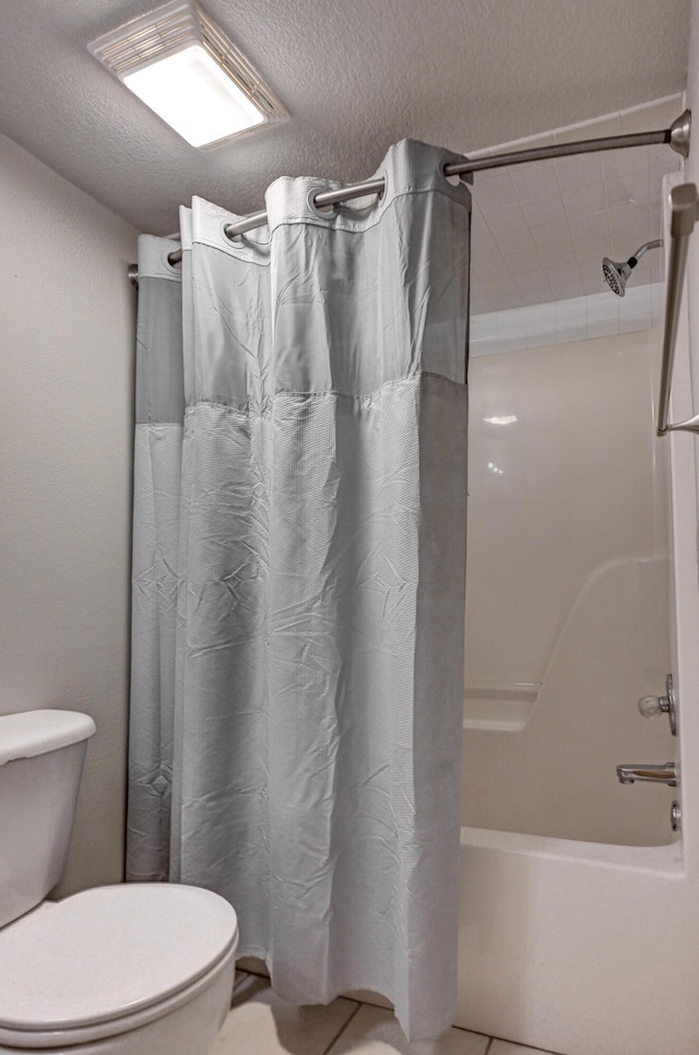 bathroom featuring tile patterned flooring, shower / bathtub combination with curtain, a textured ceiling, and toilet