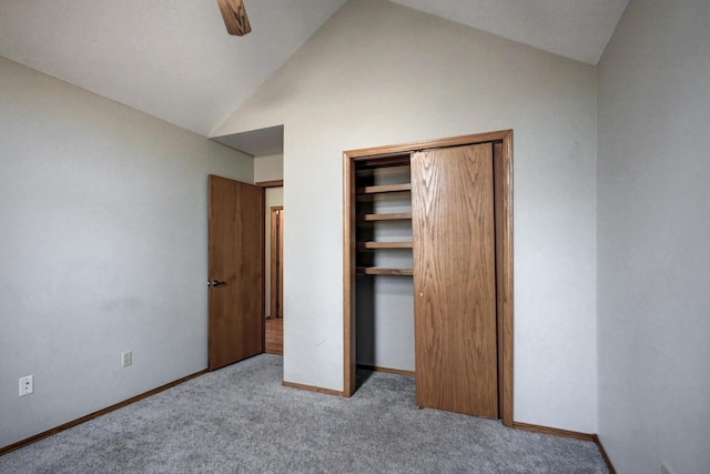 unfurnished bedroom with ceiling fan, a closet, light carpet, and vaulted ceiling