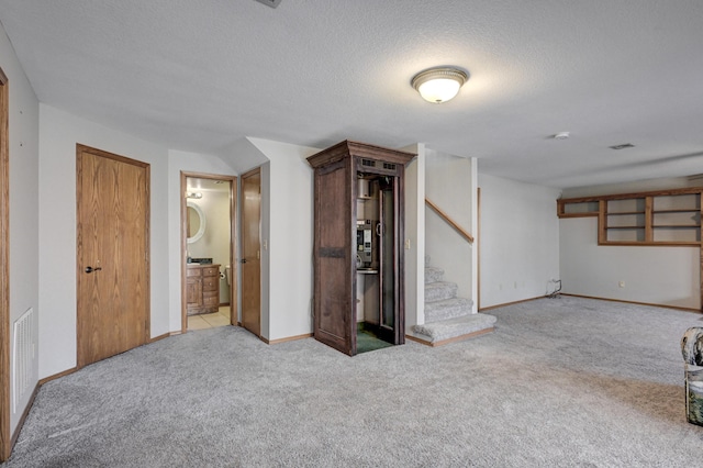 basement with light colored carpet and a textured ceiling