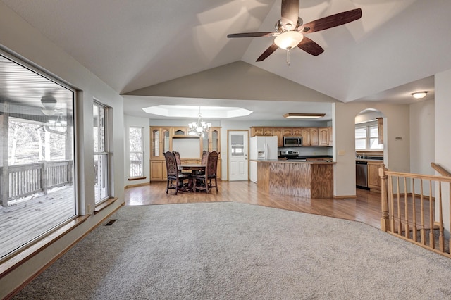 living room featuring ceiling fan with notable chandelier, light hardwood / wood-style floors, and lofted ceiling