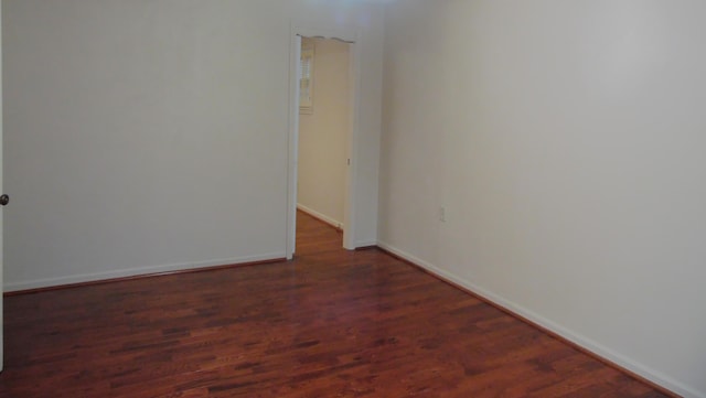 unfurnished room with dark wood-type flooring