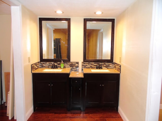 bathroom featuring decorative backsplash, vanity, and hardwood / wood-style flooring