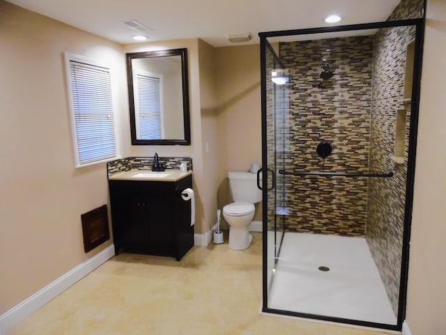 bathroom featuring vanity, toilet, and a shower with shower door