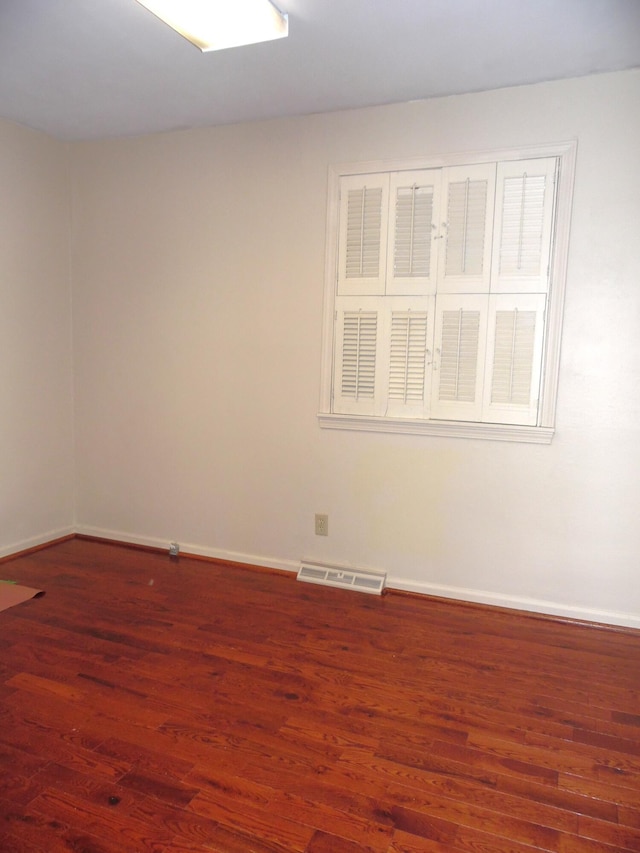 unfurnished room featuring dark wood-type flooring