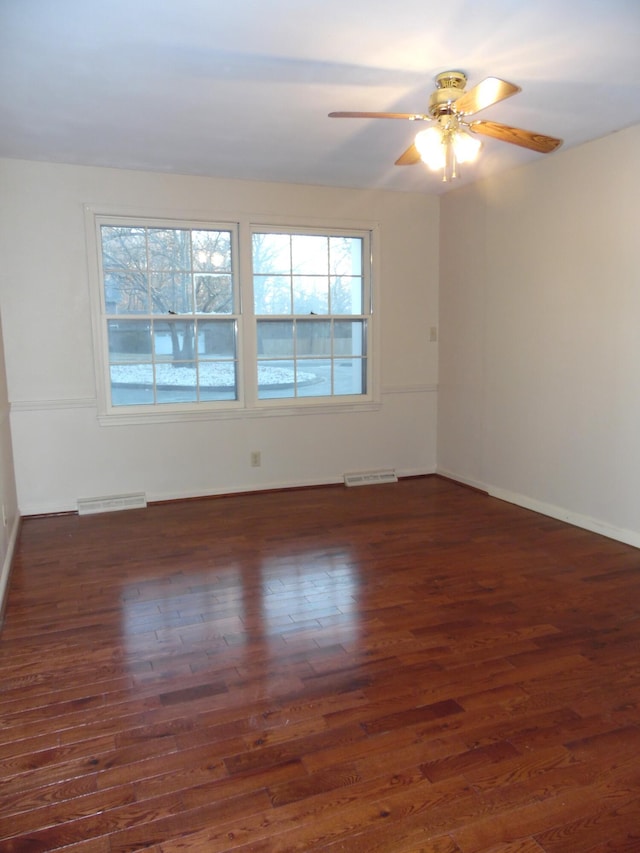 spare room with ceiling fan, a healthy amount of sunlight, and dark hardwood / wood-style floors