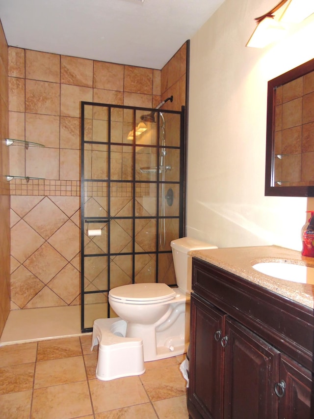 bathroom featuring toilet, vanity, and tiled shower