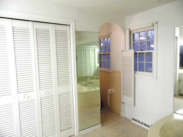 hall featuring tile walls and light tile patterned flooring