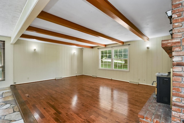 3011 E Lamonta Dr, Springfield, MO 65804 - unfurnished living room with hardwood / wood-style floors, a wood stove, and beam ceiling