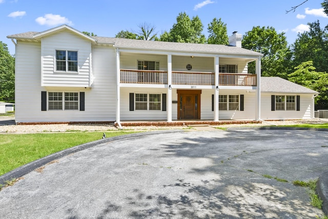 3011 E Lamonta Dr, Springfield, MO 65804 - view of front facade featuring a balcony, a chimney, covered porch, and driveway