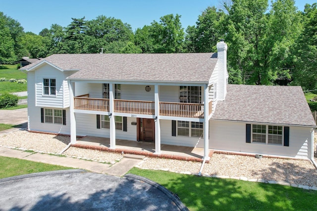 3011 E Lamonta Dr, Springfield, MO 65804 - view of front of house with a balcony, a chimney, roof with shingles, and view of wooded area
