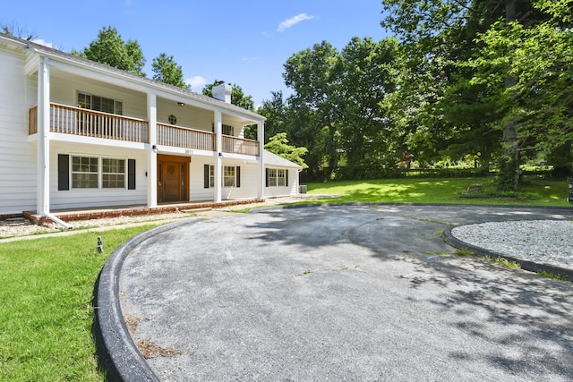3011 E Lamonta Dr, Springfield, MO 65804 - view of front of house with a chimney, a balcony, a front lawn, and a porch
