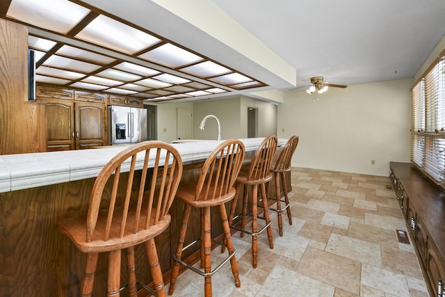 3011 E Lamonta Dr, Springfield, MO 65804 - bar featuring stainless steel fridge, ceiling fan, and light stone finish flooring