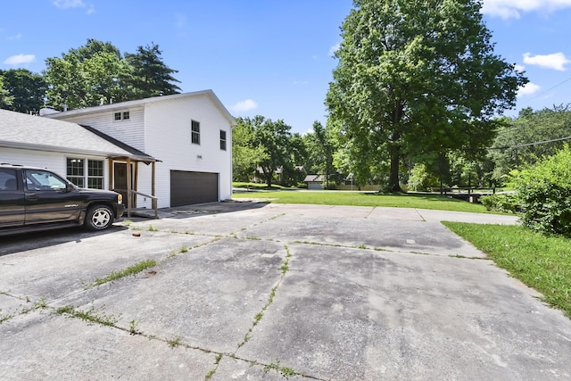 3011 E Lamonta Dr, Springfield, MO 65804 - view of side of home featuring a garage, driveway, and a lawn