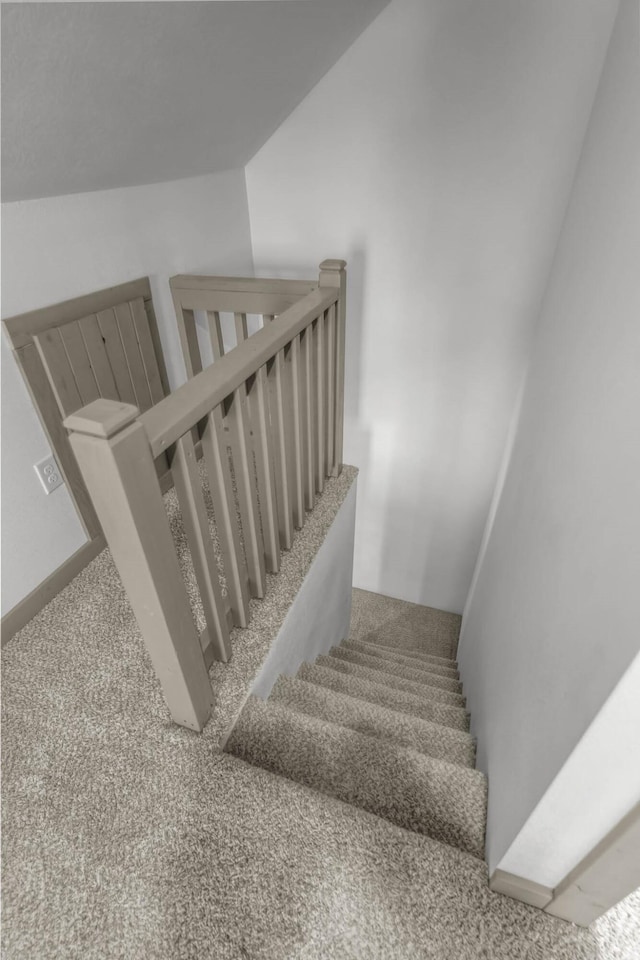 stairway with carpet and lofted ceiling