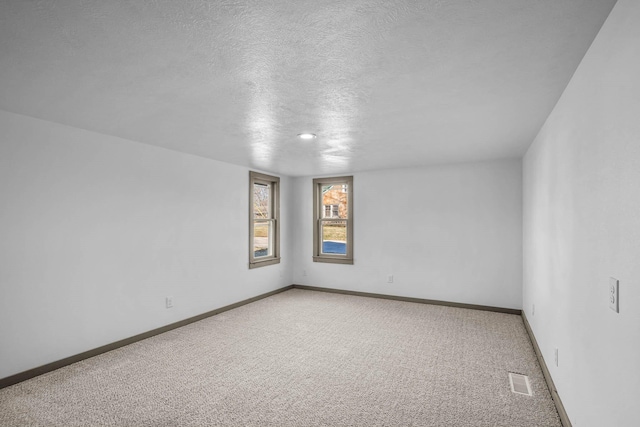 carpeted spare room featuring a textured ceiling