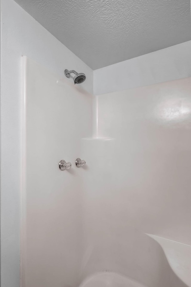 bathroom with a textured ceiling and walk in shower