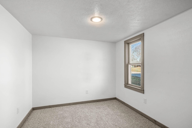 carpeted spare room with a textured ceiling