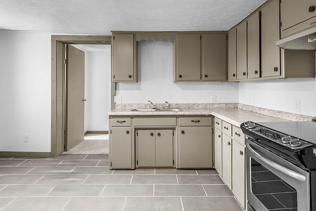 kitchen featuring a textured ceiling, sink, light tile patterned floors, and stainless steel electric range