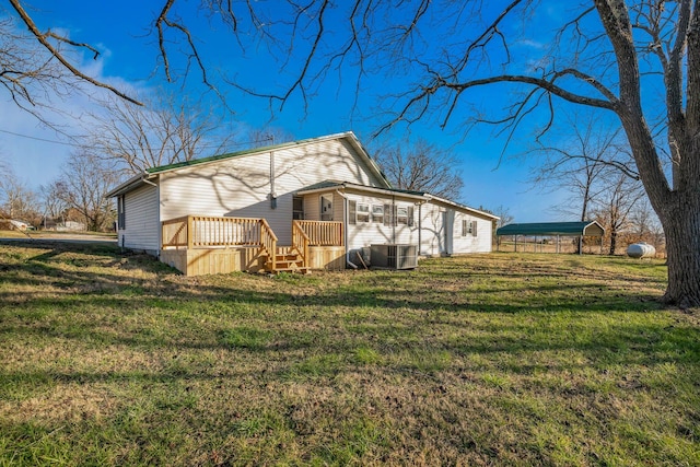 exterior space featuring a lawn, a wooden deck, central AC unit, and a carport