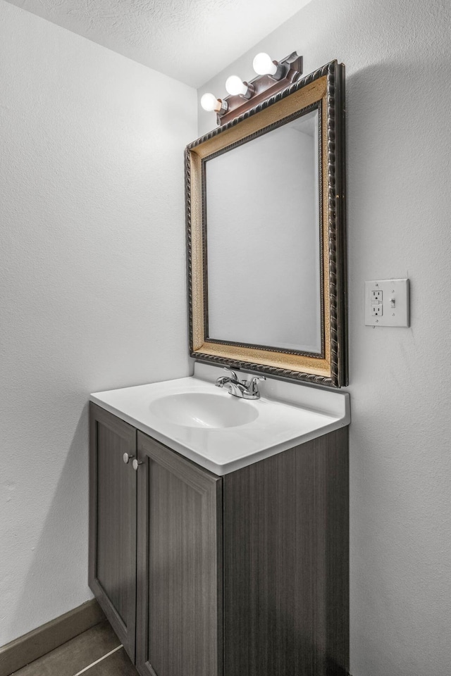 bathroom with tile patterned floors, vanity, and a textured ceiling