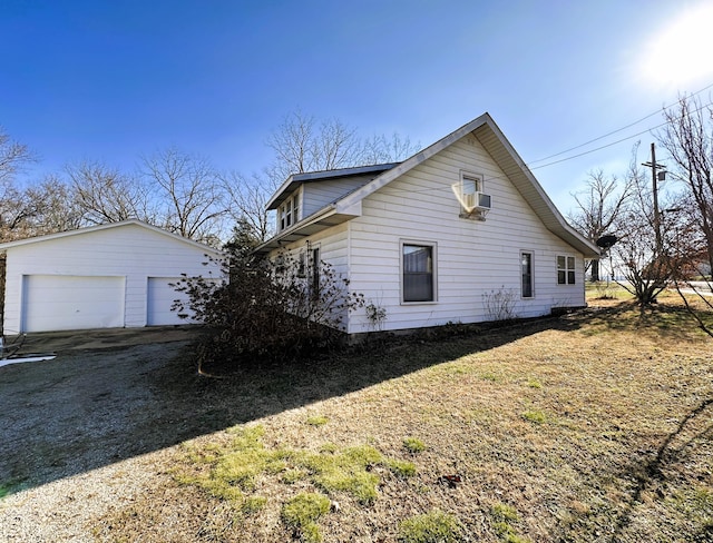 view of home's exterior with a garage, an outdoor structure, and a lawn