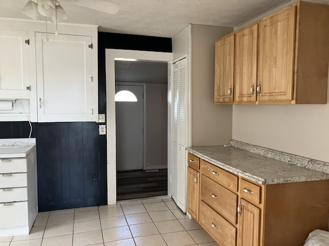 kitchen with a textured ceiling, ceiling fan, and light tile patterned flooring