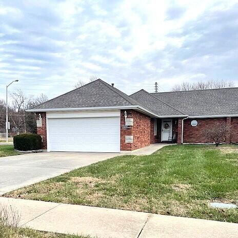 ranch-style home with a front lawn and a garage