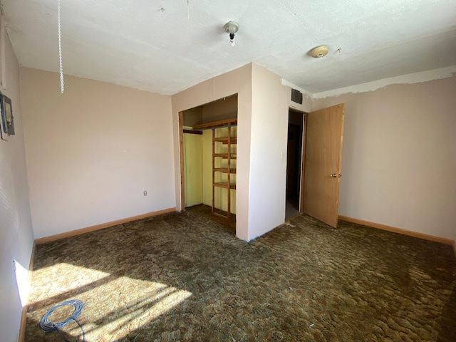 unfurnished bedroom featuring carpet, a textured ceiling, and a closet