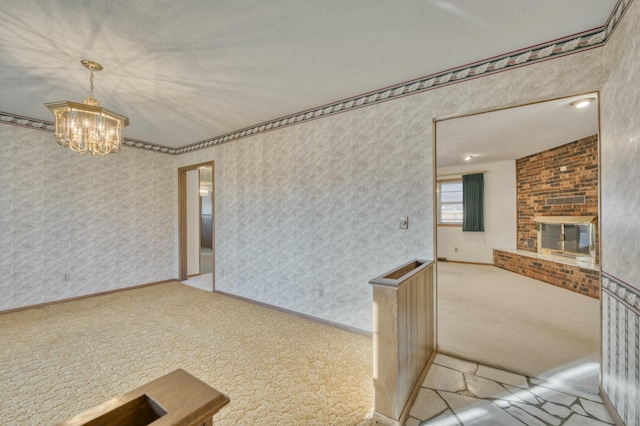 spare room featuring a notable chandelier, light colored carpet, and a fireplace