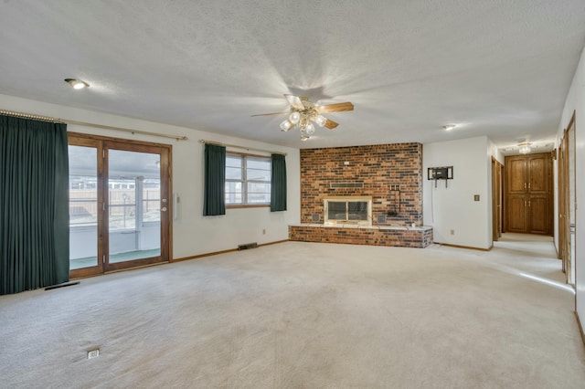 unfurnished living room with light carpet, a fireplace, ceiling fan, and a textured ceiling