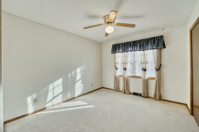 empty room with ceiling fan and light carpet