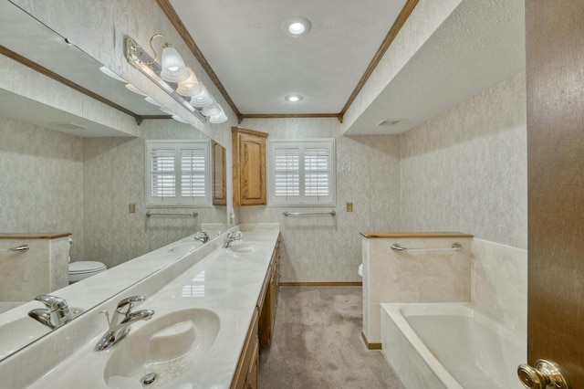 bathroom featuring vanity, toilet, ornamental molding, a textured ceiling, and a tub