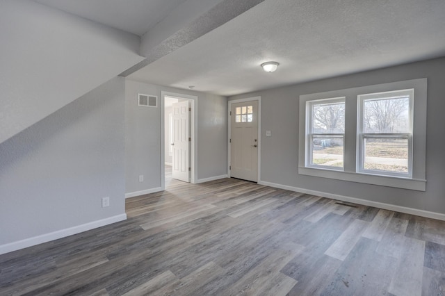 foyer entrance featuring hardwood / wood-style floors and a textured ceiling