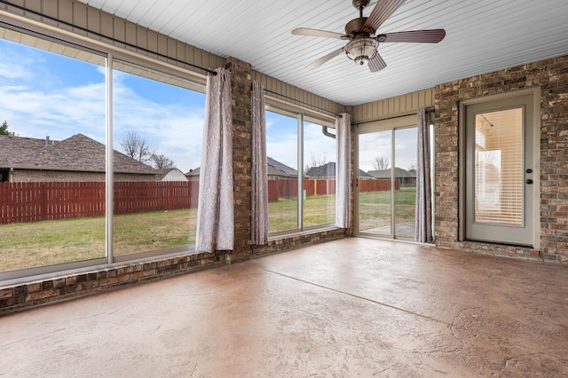 unfurnished sunroom featuring ceiling fan