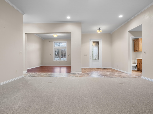 carpeted foyer entrance featuring crown molding