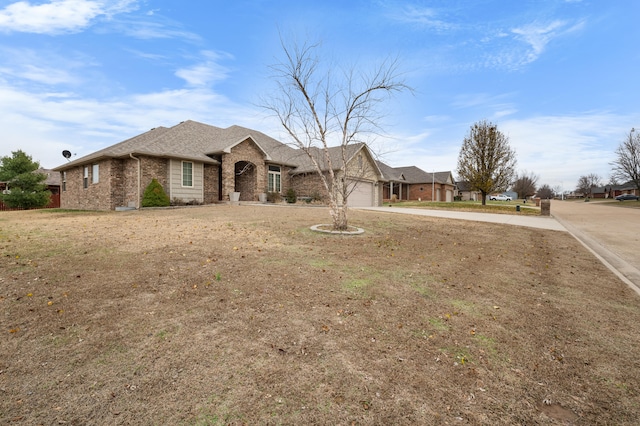 ranch-style house featuring a garage and a front lawn