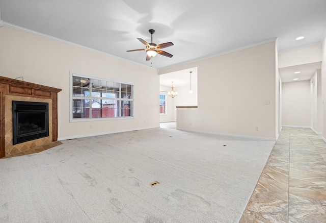 unfurnished living room featuring ceiling fan with notable chandelier, ornamental molding, light carpet, and a tiled fireplace