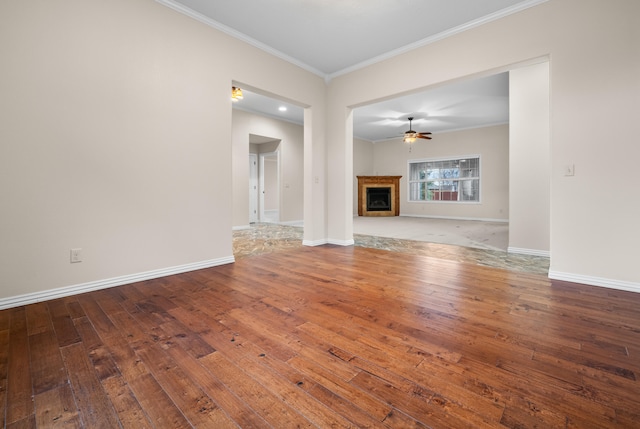 unfurnished living room featuring ceiling fan, wood-type flooring, and ornamental molding