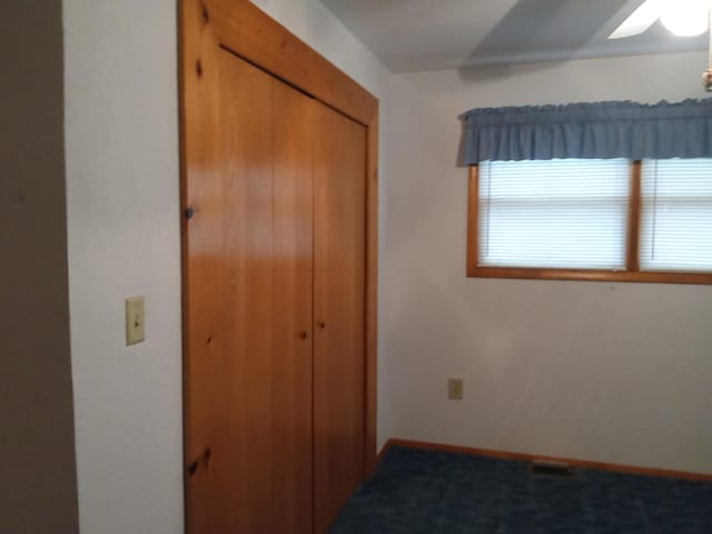 unfurnished bedroom featuring carpet flooring, ceiling fan, and a closet