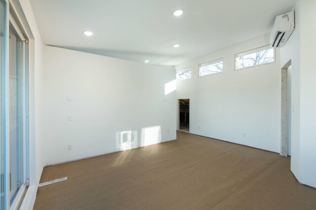 spare room featuring carpet flooring and a wall mounted AC